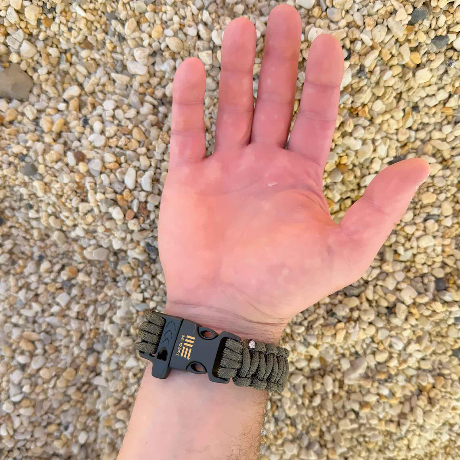 WE Knife Survival Bracelet - Überlebensarmband aus Paracord mit Signalpfeife – Größenvergleich in der Hand